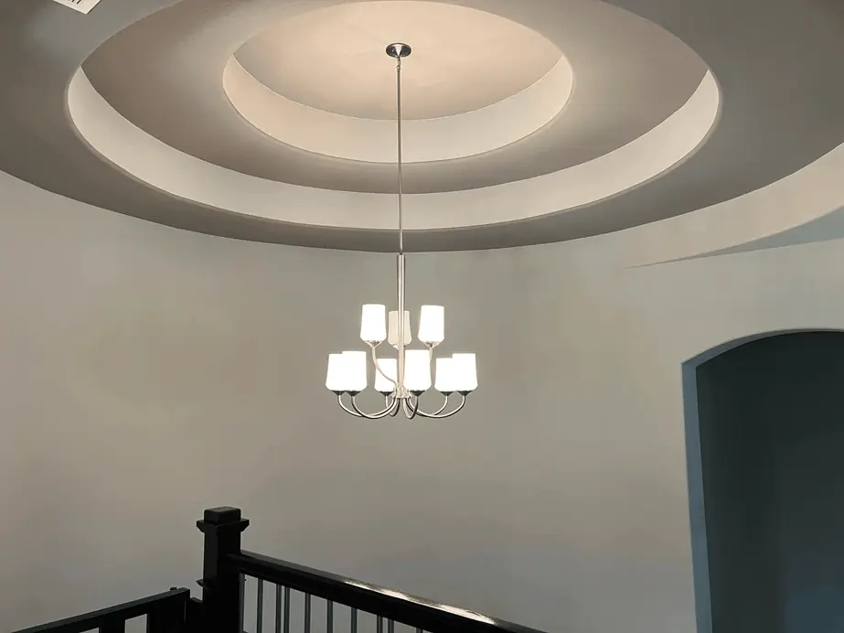 Chandelier centred in a stepped round ceiling above a staircase