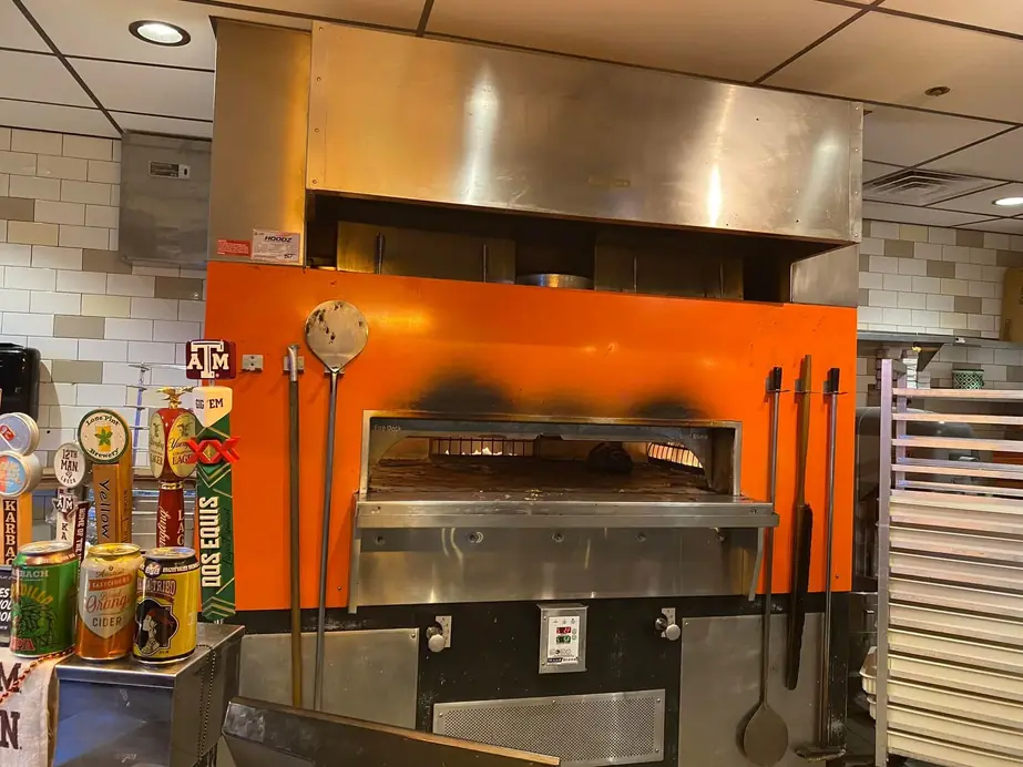 Commercial kitchen with an oven under an exhaust hood